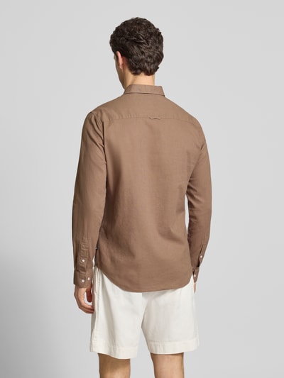 Männermodel trägt Regular Fit vrijetijdsoverhemd met mix van linnen en katoen van Matinique, button-downkraag, knoopsluiting, borstzak, ruglengte bij maat M 64 cm, schouderbreedte 43 cm, mouwlengte 68 cm, effen bruin, textuur glad, Ganzkörperansicht Rückansicht.