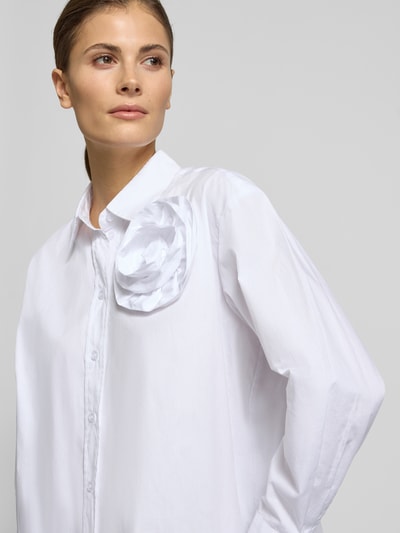 Frauenmodel trägt Hemdbluse mit Knopfleiste von Christian Berg Woman Selection aus reiner Baumwolle, lockerer Schnitt, Zierbesatz, Nahaufnahme Oberkörper.