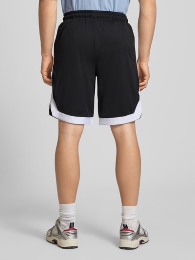 Männermodel trägt Relaxed Fit Shorts mit elastischem Bund von Pegador in Schwarz-Weiß mit Logo-Stitching und Eingrifftaschen, Ganzkörperansicht Rückansicht.