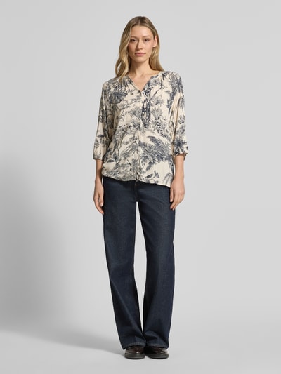 Frauenmodel trägt Relaxed Fit Bluse aus Viskose Modell 'CARLI' von Soyaconcept, cremeblauer Allover-Look, V-Ausschnitt, Ganzkörperansicht von vorne.
