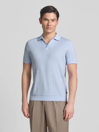 Männermodel trägt Regular Fit Poloshirt mit V-Ausschnitt Modell 'Baronito' von JOOP! Collection aus reiner Baumwolle, Strukturmuster, Ganzkörperansicht von vorne.