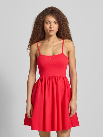Kobiece model prezentuje Tailliertes Freizeitkleid aus reiner Baumwolle od Tommy Jeans, efekt: jednolity kolor, krój: taliowany, długość: mini, dekolt w łódkę, wyhaftowane logo, cienkie ramiączka, prosty dół, wpuszczane kieszenie, 100% bawełna, widok całej sylwetki od przodu.