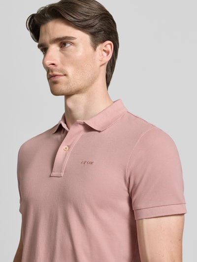 Männermodel trägt Slim Fit Poloshirt mit Logo-Stitching von Geox in Rosa, Strukturmuster, Kurzarm, Polokragen, Nahaufnahme Oberkörper