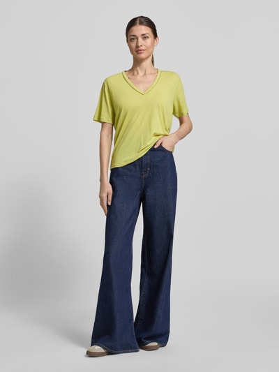 Frauenmodel trägt Regular Fit T-Shirt aus Leinen-Mix mit V-Ausschnitt von Scotch & Soda, Damen T-Shirt mit Lochmuster, Rückenlänge 62 cm, Ganzkörperansicht von vorne.