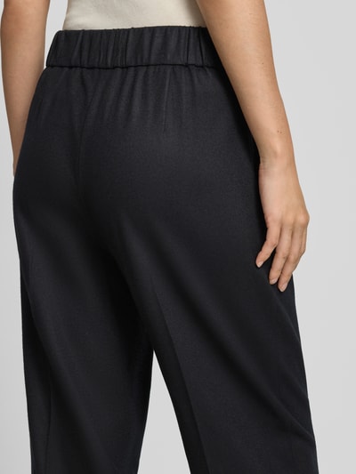 Frauenmodel trägt Barrel Fit Hose aus Woll-Mix von windsor., dunkler Stoff mit feiner Textur, elastischer Bund, Nahaufnahme Rückansicht. Damen Hose, Bundweite 37 cm, Innenbeinlänge 69 cm.