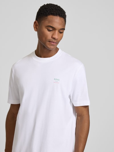 Męski model nosi Regular Fit T-Shirt aus reiner Baumwolle Modell 'TE_GROOVE' od BOSS Orange, biały, krój regular fit, nadruk, jersey, bawełna, zbliżenie górnej części ciała.