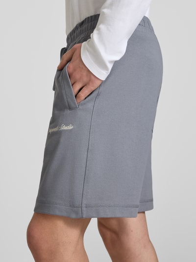 Männermodel trägt Shorts mit Label-Stitching Modell 'KARL' von Jack & Jones in Grau, Baumwoll-Mix, seitliche Taschen, Nahaufnahme Oberschenkel.