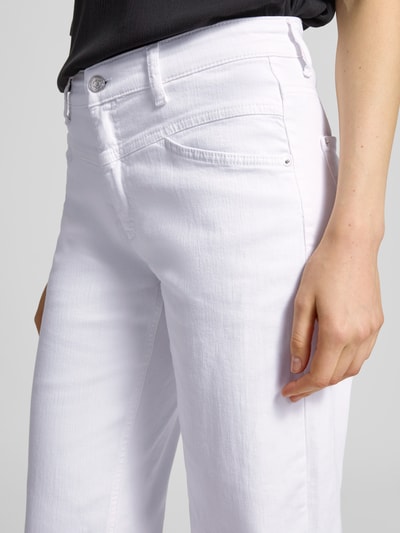 Frauenmodel trägt Barrel Fit Jeans Modell 'ELIN' von Cambio aus weißem Baumwoll-Mix mit Stretch-Anteil, Eingrifftaschen, Nahaufnahme Oberkörper. Bundweite bei Größe 36: 40 cm, Innenbeinlänge bei Größe 36: 65 cm.