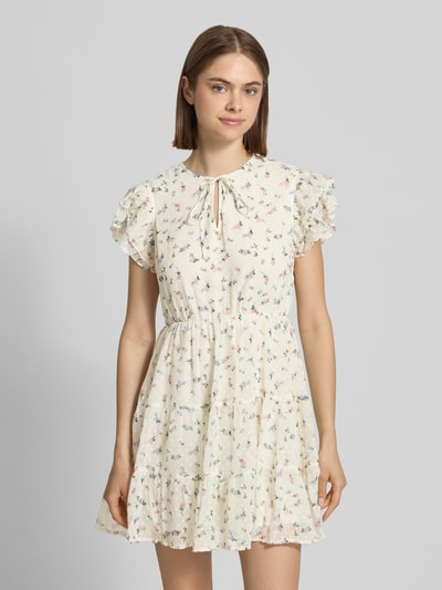 Frauenmodel trägt Tailliertes Freizeitkleid mit Volants Modell 'ELIZA' von Only, florales Allover-Muster, Mini-Länge, Crinkle-Material, Rundhals, Ganzkörperansicht von vorne.