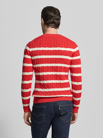 Männermodel trägt Slim Fit Pullover in Strick-Optik von Gant, rot-beige gestreift aus reiner Baumwolle, Rückenansicht, Ganzkörperansicht Rückansicht.