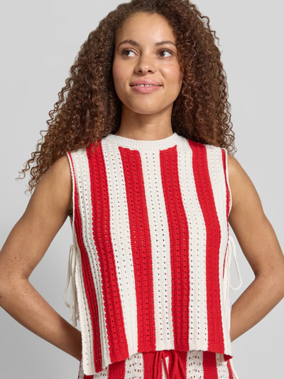 Frauenmodel trägt Strickshirt mit seitlicher Schnürung von Karo Kauer in Rot-Weiß, Baumwoll-Mix, Straight Fit, Rundhalsausschnitt, Nahaufnahme Oberkörper. Rückenlänge bei Größe S: 47 cm.
