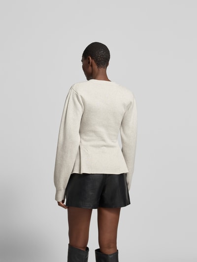 Frauenmodel trägt Cardigan mit Kaschmir-Anteil von ROTATE in Beige mit Strick-Optik, taillierter Passform und Kellerfalte, Ganzkörperansicht Rückansicht.