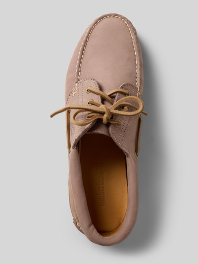 Produktfoto, Bootsschuhe aus Leder mit profilierter Sohle von Timberland in Beige mit abgerundeter Spitze und Schnürung, Größe 44, Strukturdetails. Kontext: Echtes Leder, Absatzhöhe 3 cm, Schafthöhe 7 cm, Schaftweite 9 cm.