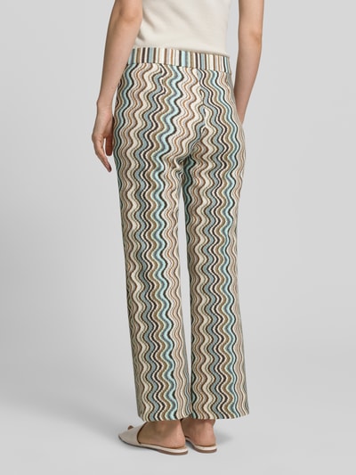 Frauenmodel trägt Hose in verkürzter Passform Modell 'FAITH' von Cambio, Modal-Mix mit Viskose-Anteil, Wellenmuster in Beige, Braun und Blau, elastischer Bund, Ganzkörperansicht Rückansicht, Bundweite bei Größe 36: 35 cm, Innenbeinlänge 78 cm.