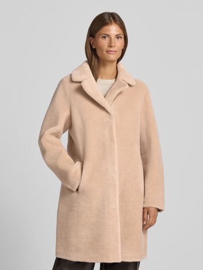 Frauenmodel trägt Wendemantel in Woll-Lammfell-Optik Modell 'VENUS' von OAKWOOD in Beige mit Reverskragen, Eingrifftaschen, lockere Passform, Ganzkörperansicht von vorne.