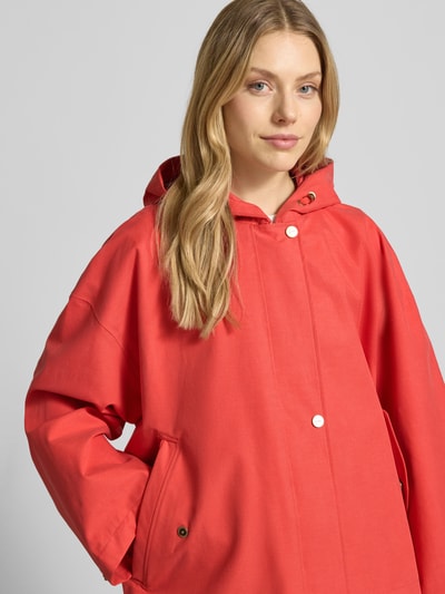 Frauenmodel trägt Jacke mit Kapuze und versiegelten Nähten Modell 'ELLE' von G-LAB aus Lyocell-Mix mit Leinen-Anteil in Rot, Nahaufnahme Oberkörper.