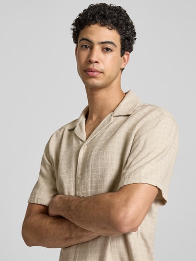 Männermodel trägt Regular Fit Freizeithemd aus Viskose-Leinen-Mix Modell 'LATHAM' von Only & Sons in Beige mit Strukturmuster, Nahaufnahme Oberkörper.