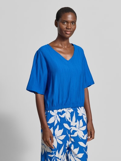 Frauenmodel trägt Relaxed Fit Blusentop aus Viskose-Mix von s.Oliver RED LABEL in Blau mit floralem Allover-Muster, Satinstruktur, Ganzkörperansicht von vorne.