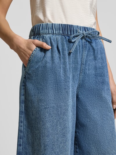 Frauenmodel trägt Wide Leg Jeans aus Baumwoll-Viskose-Mix Modell 'VALERIA' von Vero Moda in Denim-Optik mit Tunnelzug und seitlichen Eingrifftaschen, Nahaufnahme Oberkörper.