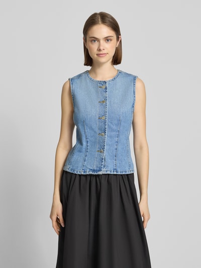 Frauenmodel trägt Regular Fit Jeansweste aus reiner Baumwolle Modell 'AYA' von Only, hellblauer Denim, einreihige Knopfleiste, Ganzkörperansicht von vorne.