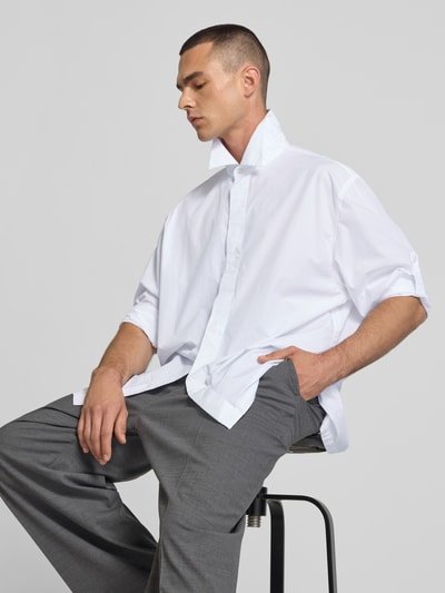 Männermodel trägt wit vrijetijdsoverhemd met Kentkraag van Filippa K, puur katoen, relaxed fit, met lange mouwen, knoopsluiting, zijaanzicht medium close-up.