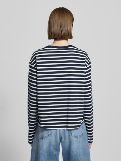 Kobiece model prezentuje Loose Fit Langarmshirt aus reiner Baumwolle von Marc O'Polo Denim, efekt: w paski, wzór: paski, okrągły dekolt, 100% bawełna, aplikacja: wyhaftowane logo, kolor: granatowo-biały, widok całej sylwetki z tyłu.