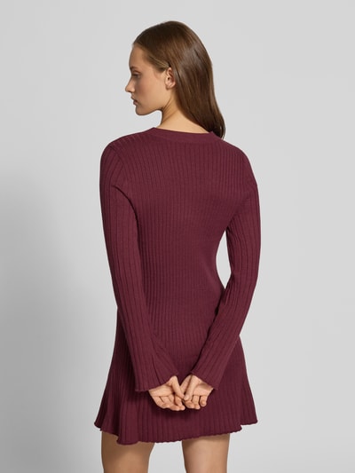Frauenmodel trägt eng anliegendes Freizeitkleid aus Viskose-Mix Modell 'MICHELLA' von ONLY in Weinrot, Rippenstruktur, Ganzkörperansicht Rückansicht, Damen Strickkleid von ONLY.