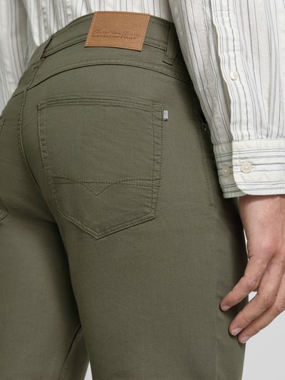 Männermodel trägt Straight Fit Hose mit Strukturmuster von Christian Berg Men in Olivgrün, 5-Pocket-Design, Detailaufnahme Rückenansicht.