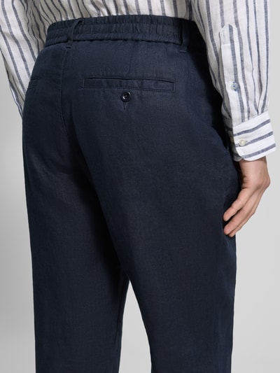 Männermodel trägt Regular Fit Leinenhose mit elastischem Bund von Gant in Dunkelblau, reine Leinen, Detailaufnahme Rückansicht.