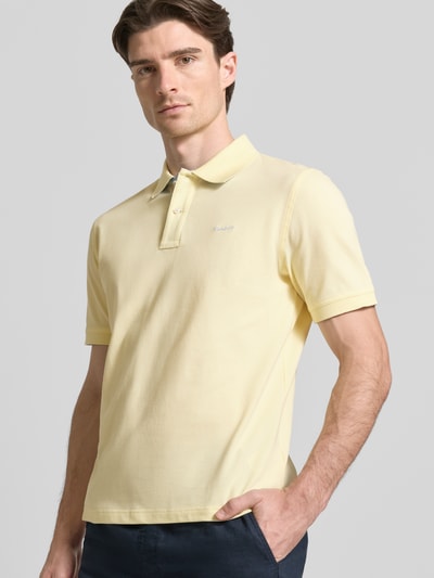 Männermodel trägt Regular Fit Poloshirt mit Logo-Stitching von Gant, gelb, Polokragen, elastischer Baumwoll-Mix, Nahaufnahme Oberkörper.