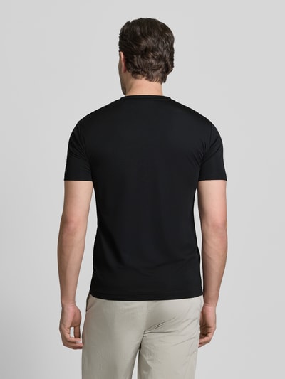 Męski model nosi T-Shirt aus Viskose-Mix mit Label-Patch od EA7 Emporio Armani, czarny, krój slim fit, widok całej sylwetki z tyłu.