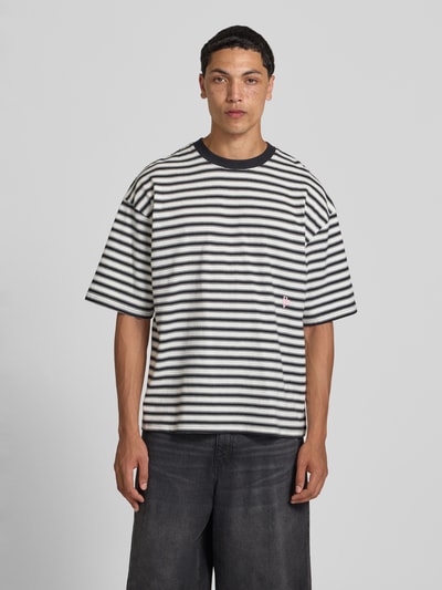 Männermodel trägt Oversized T-Shirt mit Label-Stitching von REVIEW, Herren T-Shirt aus reiner Baumwolle im Allover-Look, Rundhalsausschnitt, Rückenlänge bei Größe M 67 cm, Ganzkörperansicht von vorne.