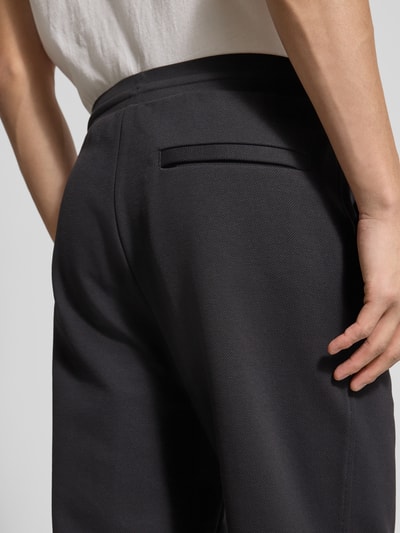 Männermodel trägt Regular Fit Sweatpants aus katoenmix Modell 'JT_Member Hurley' van BOSS Green, effen zwart, detailopname rug.
