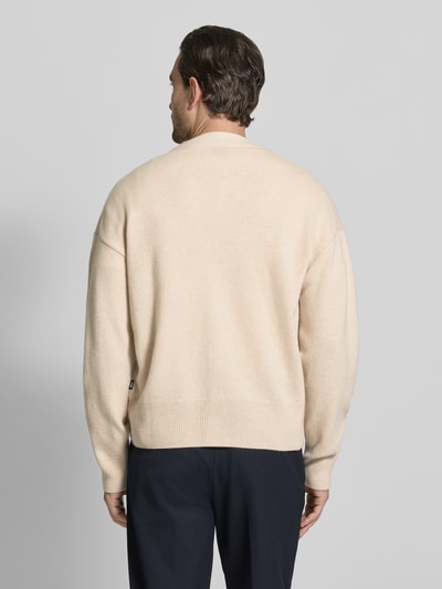 Männermodel trägt Regular Fit Strickjacke aus reiner Schurwolle Modell 'C-UCONE' von BOSS, Optik: Unifarben, Ganzkörperansicht Rückansicht.