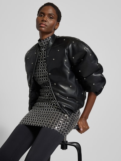 Frauenmodel trägt Jacke mit Stehkragen von ROTATE in Leder-Optik mit Ziersteinbesatz, Regular-Fit, Reißverschluss, Nahaufnahme Oberkörper. Rückenlänge 57 cm, Brustweite 51 cm, Ärmellänge 65 cm bei Größe 36.