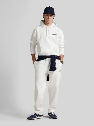Männermodel trägt Relaxed Fit Hoodie aus Baumwoll-Mix von Polo Ralph Lauren in Unifarben mit Label-Schriftzug, Ganzkörperansicht von vorne.