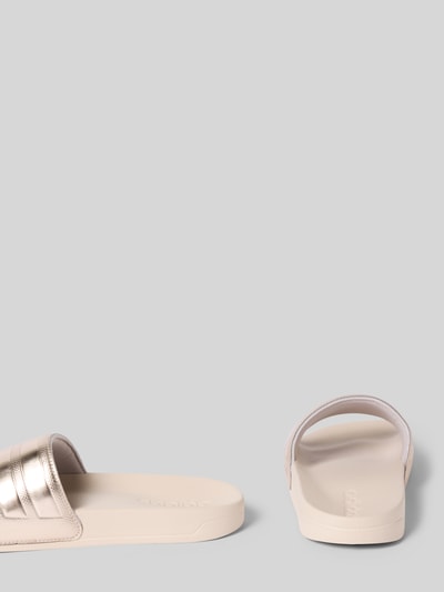 Produktfoto, Badeschuhe mit Metallic-Detail Modell 'ADILETTE SHOWER' von adidas Sportswear, efekt: jednolity kolor, zaokrąglony nosek, płaska podeszwa, metaliczny detal, bez zapięcia, podeszwa z fakturą