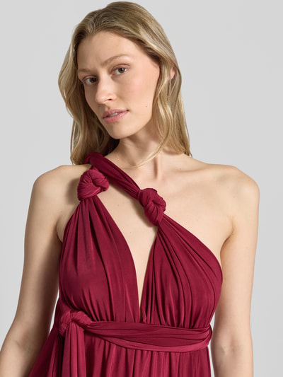 Vrouwenmodel draagt 'Knielanges Cocktailkleid mit tiefem V-Ausschnitt' van Rose Avenue in bordeaux, tailleband, gekruiste bandjes achter, getailleerde fit, kniehoogte, zachte textuur, detailopname bovenlichaam.