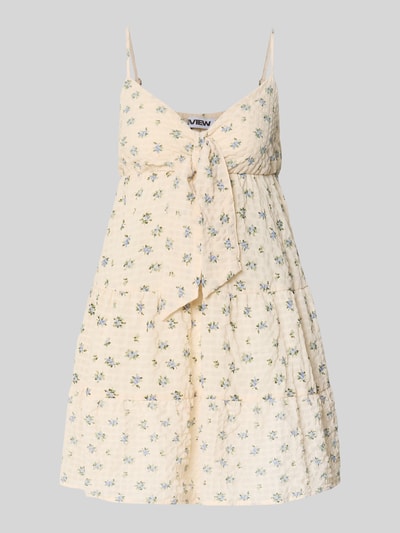 Frauenmodel trägt Minikleid mit Volantsaum und Spaghettiträgern von REVIEW in creme mit Floraler-Print auf Seersucker A-Linie, Nahaufnahme Oberkörper.