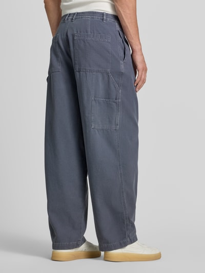 Männermodel trägt Wide Fit Jeans mit teilelastischem Bund Modell 'Lycaz' von American Vintage, puur katoen, achterzak, bandwijdte maat M 39 cm, binnenbeenlengte 71 cm, blue kleur, ganzkörperansicht rückansicht.