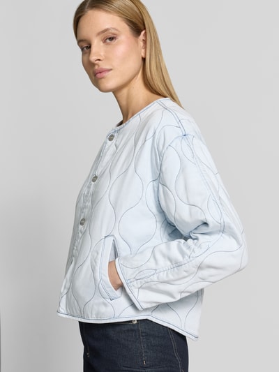 Vrouwenmodel draagt Regular Fit Jacke aus reinem Lyocell Modell 'Alina' van CARS JEANS in lichtblauw met stiksels, steekzakken, ronde hals, volledige knoopsluiting, modelinformatie uit context, detailopname zijaanzicht.