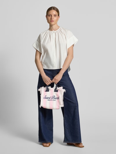 Frauenmodel trägt Handtasche mit Label-Print und Fransen Modell 'COLETTE' von MC2 Saint Barth aus reiner Baumwolle, Hauptfach mit Reißverschluss, Tragehenkel, Breite 28 cm, Länge 23 cm, Tiefe 14 cm, Schulterriemen 117 cm, ganzkörperansicht von vorne.