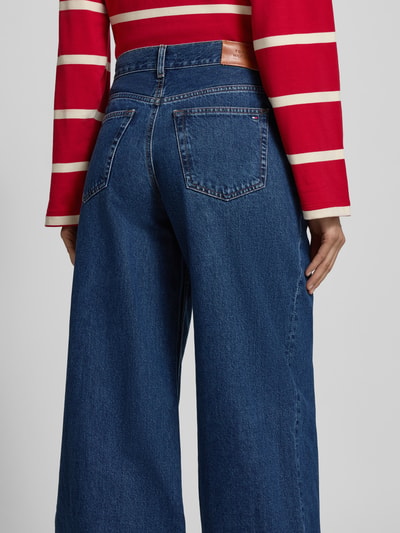 Frauenmodel trägt Wide Leg Jeans aus reiner Baumwolle von Tommy Hilfiger in Denim-Optik mit Label-Patch, Kontrastnähten und 5-Pocket-Design, Ganzkörperansicht Rückansicht.