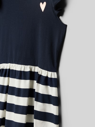 Mädchen trägt Regular Fit Kleid mit Rüschenbesatz von Blue Seven, navy und weiß gestreift, elastischer Baumwoll-Mix, Nahaufnahme Oberkörper.
