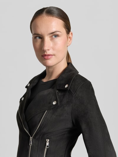 Kobieta nosi Regular Fit Kunstlederjacke mit Riegeln am Rumpf Modell 'JOSE' od VERO MODA w czerni, matowa faktura, zdjęcie zbliżenie górnej części ciała.