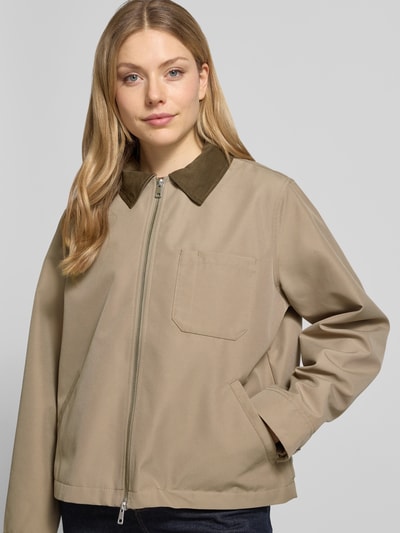 Frauenmodel trägt Jacke mit Zweiwege-Reißverschluss Modell 'ROBINSON' von Samsøe Samsøe in Beige mit Umlegekragen und Brusttasche, Regular-Fit, Nahaufnahme Oberkörper. Rückenlänge 61 cm, Schulterbreite 43 cm, Brustweite 41 cm, Ärmellänge 64 cm bei Größe S.