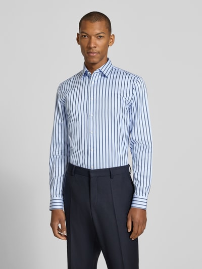 Männermodel trägt Slim Fit Businesshemd aus reiner Baumwolle von Jake*s, weiß mit blauen Streifen, Ganzkörperansicht von vorne.