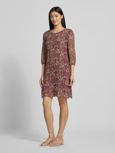 Frauenmodel trägt Knielanges Kleid mit Schlüssellochausschnitt von ZABAIONE, gemustert in Rot und Beige, Falten-Optik, Ganzkörperansicht von vorne. Relaxed Fit, 1/2-Arm, Rückenlänge bei Größe S 93 cm, Brustweite 47 cm, Ärmellänge 44 cm.