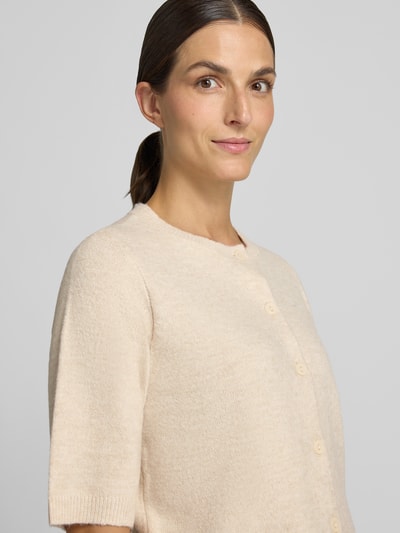 Frauenmodel trägt Regular Fit Cardigan in Strick-Optik Modell 'Iga' von VILA in Beige, elastischer Material-Mix, Nahaufnahme Oberkörper.