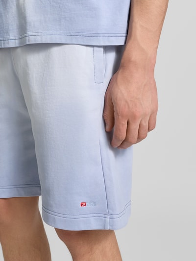 Männermodel trägt Sweatshorts aus reiner Baumwolle von Diesel in Hellblau mit Label-Print, Gerade Passform, Nahaufnahme Oberschenkel.